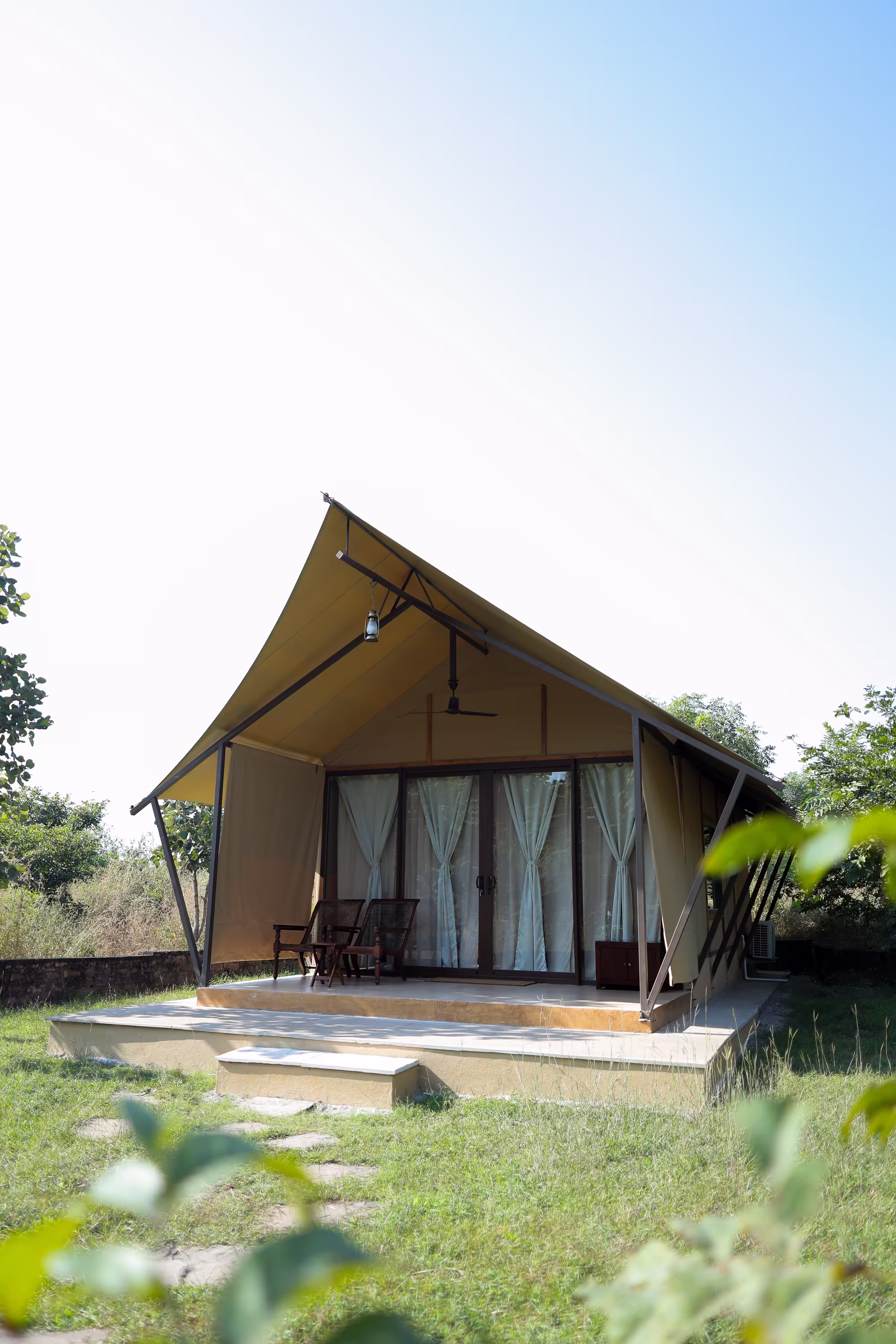 Luxury glamping tent with deck overlooking greenery